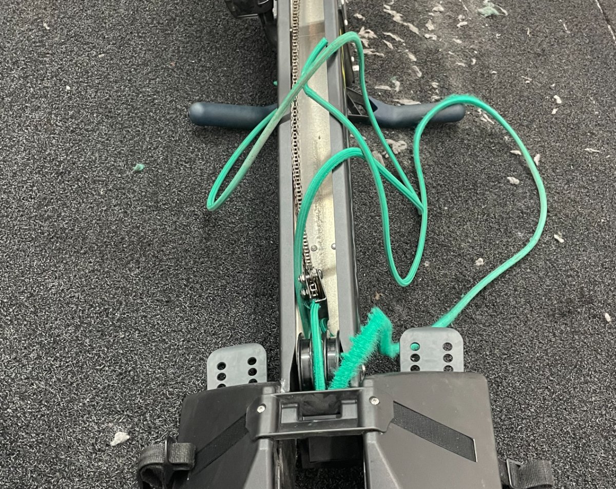 Élastique de rappel et chaîne d'un rameur RowErg Concept 2 pendant une réparation
